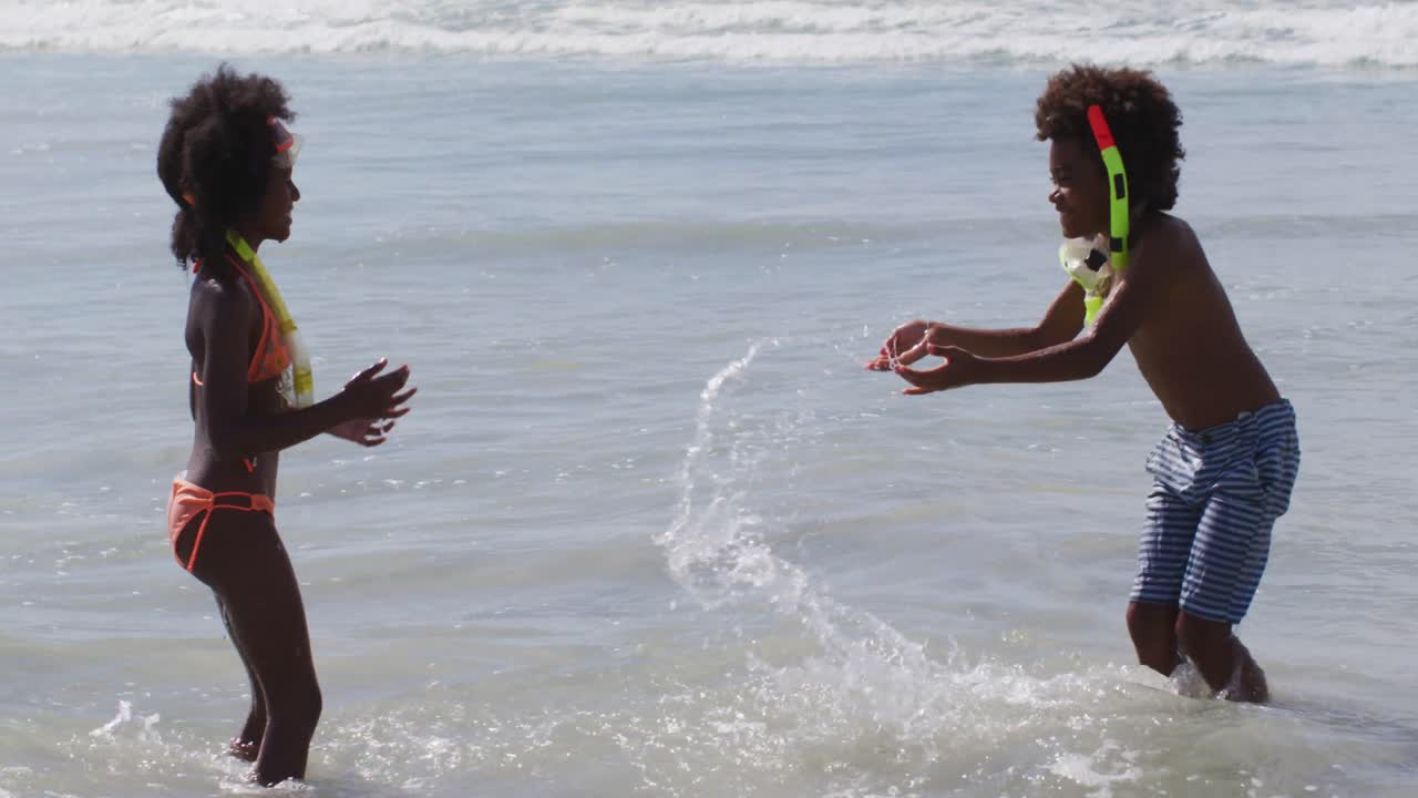 niños afroamericanos con gafas de buceo jugando en la playa