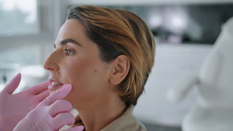 cosmetologist examining facial skin woman in clinic closeup. expert diagnosing.