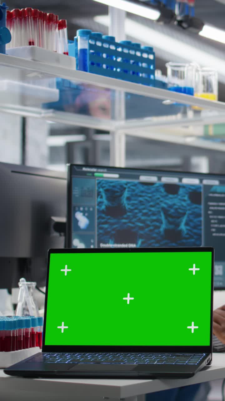 Vertical video Cytotechnologist works on green screen laptop in lab