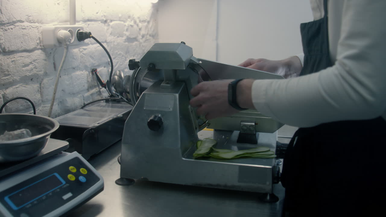 Chef Slicing Zucchini on a Food Slicer
