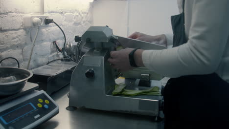 Chef Slicing Zucchini on a Food Slicer
