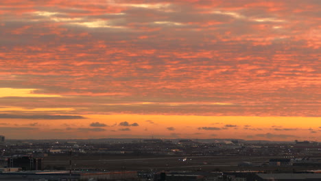 Aerial-panning-shot-of-airport-in-Toronto-during-golden-sunset-at-sky