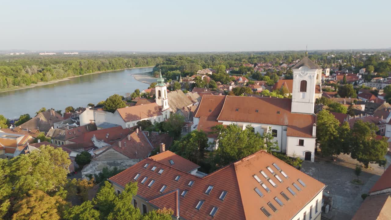 Drone die langs de kerken van Szentendre vliegt en de daken, torens en historische skyline van de stad vastlegt