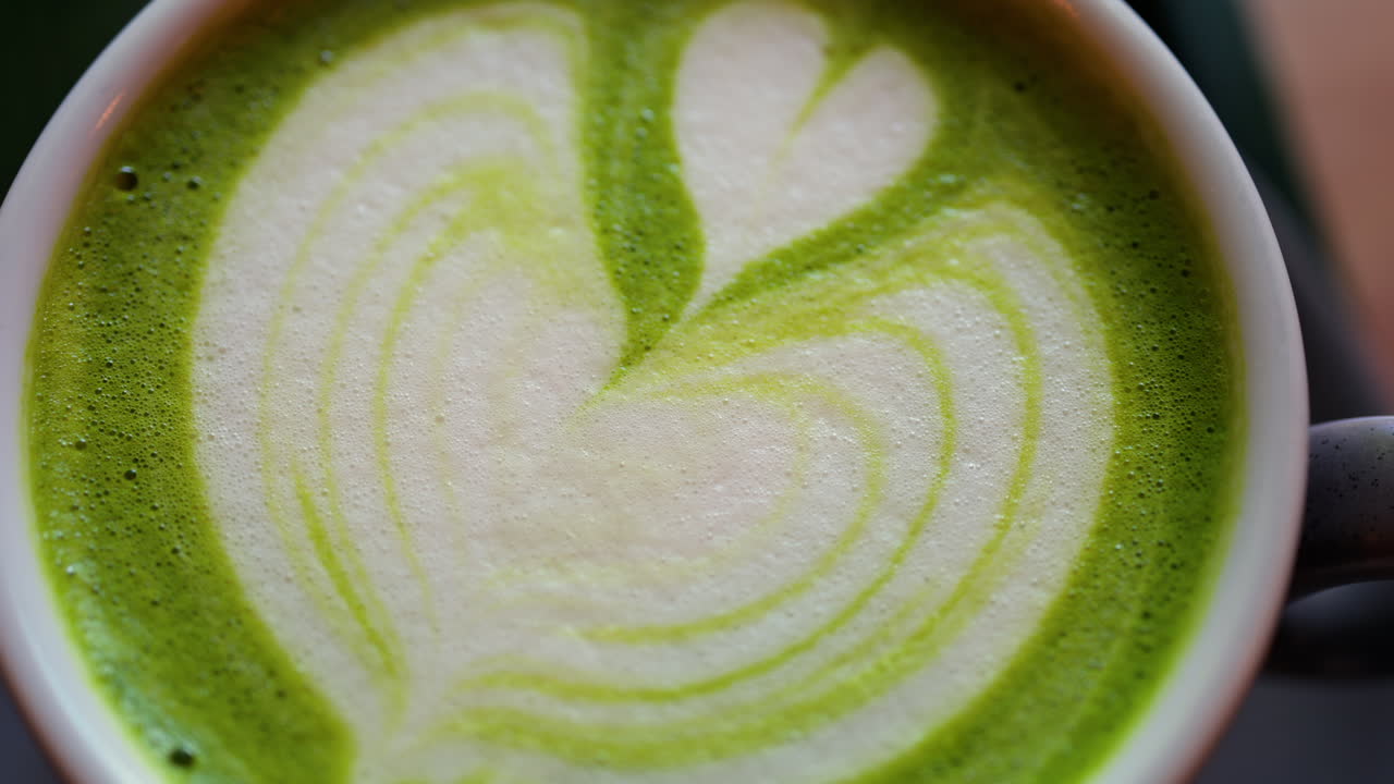 Close up of a matcha latte on a little green tray at a cafe