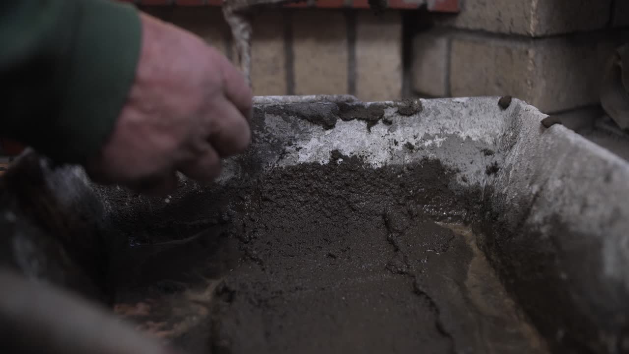 건설 작업 중 벽돌에 시멘트를 는 손의 클로즈업