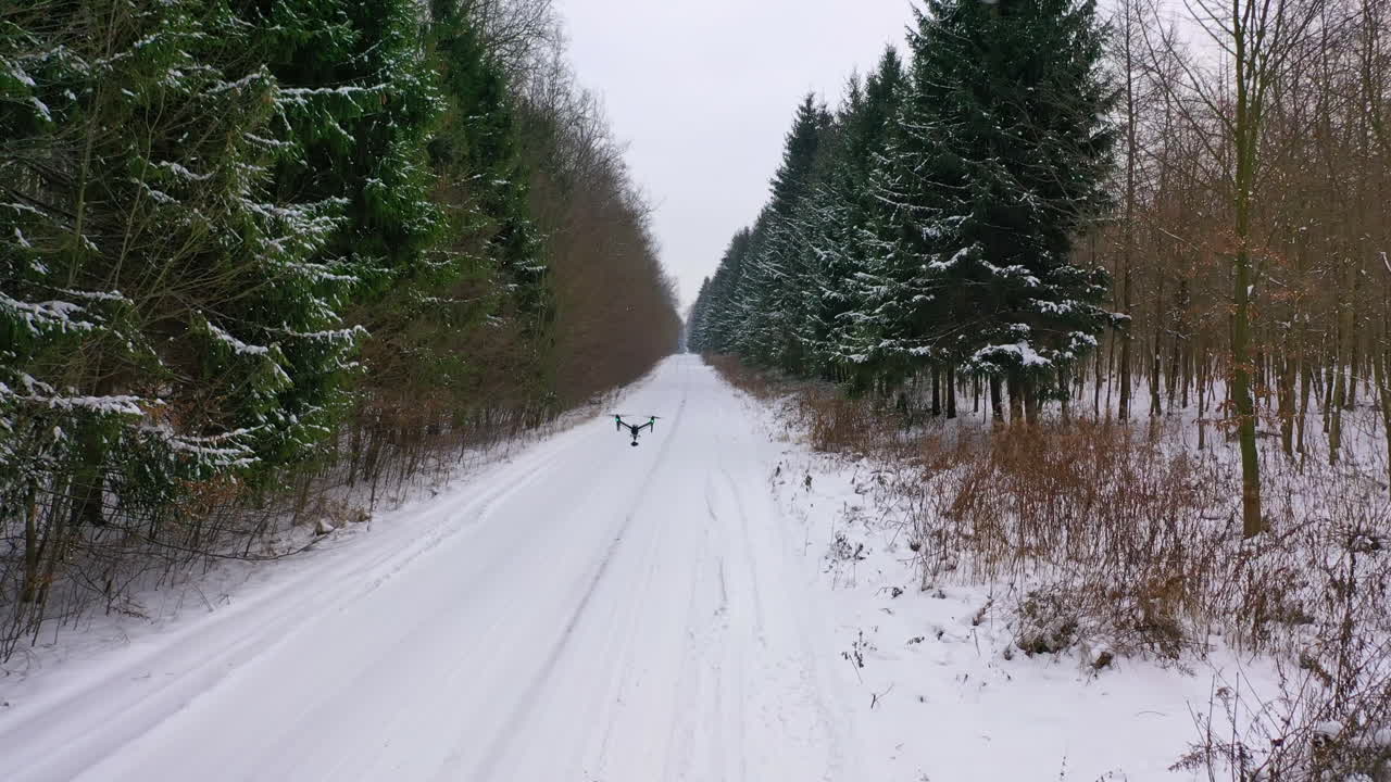 Drone flying over forest. Flying drone on the background of snow covered forest