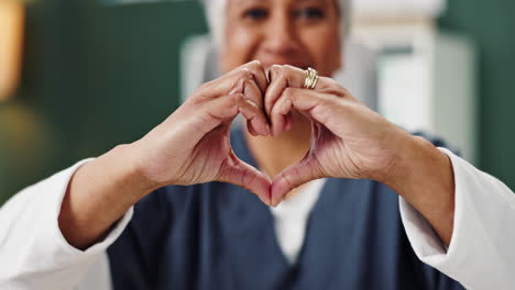 senior woman making heart shape with hands