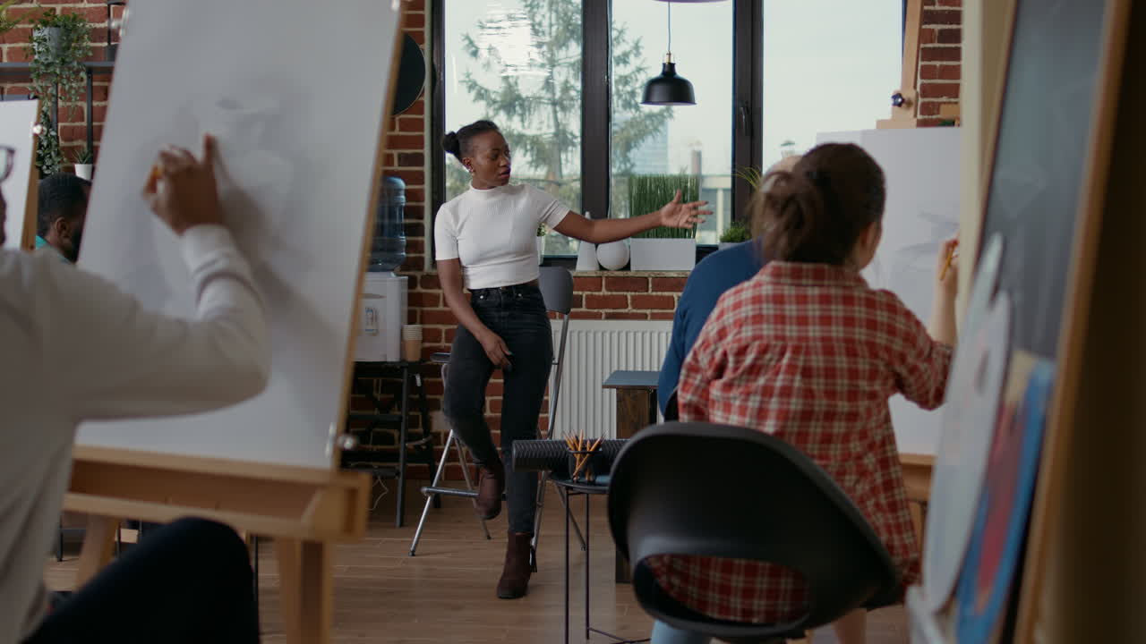 Young teacher explaining drawing skills to students in art class