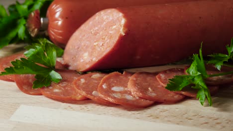 salchicha de pepperoni en rodajas en una tabla de madera con perejil