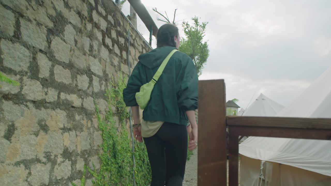 Female Tourists Walking through Glamping Resort in Mountains