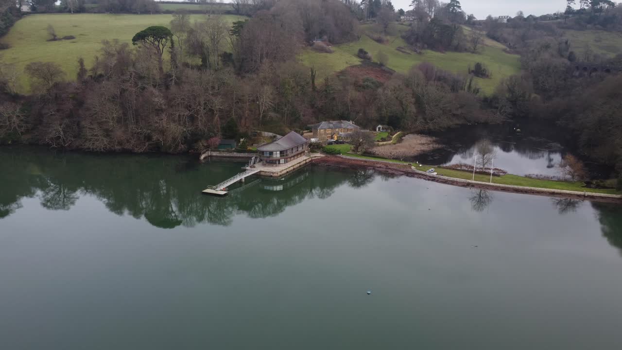 аэрофотосъемка потрясающего дома на воде с большим озером за спиной