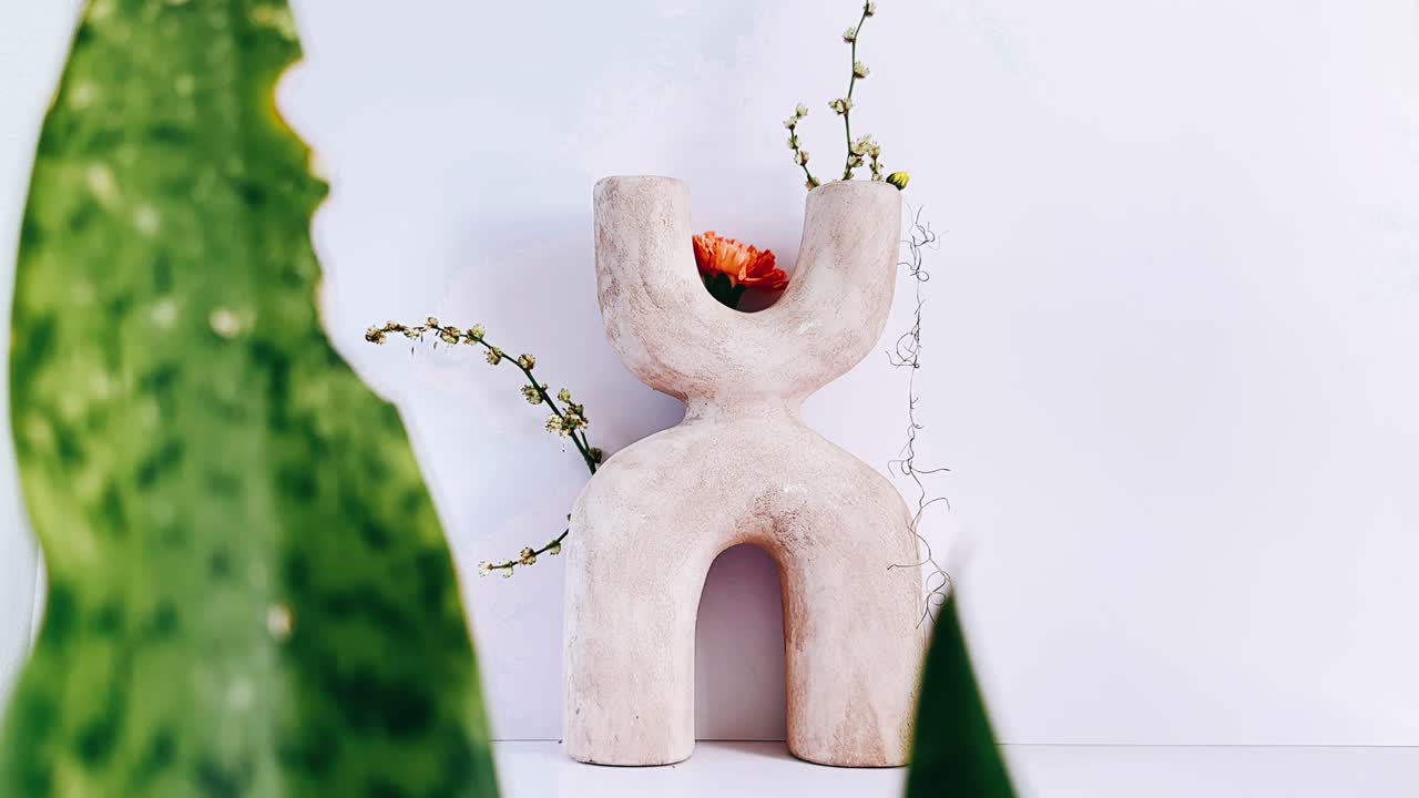 꽃과 식물이 있는 베이지 조각 꽃병