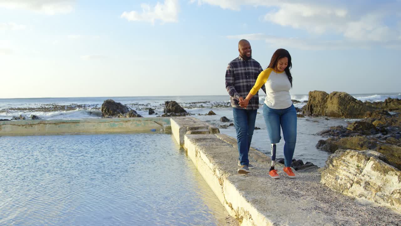 Casal feliz caminhando de mãos dadas em um píer 4k
