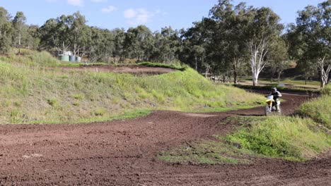 cyclist rides across a dirt trail in a lush park