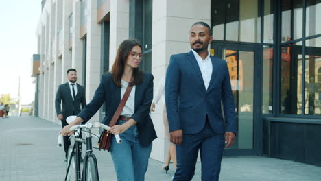 business colleagues walking and talking outside office building