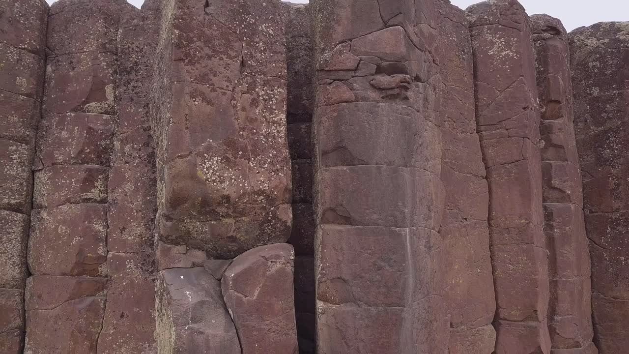 Le Scablands mostrano colonne di roccia basaltica fessurate verso il cielo bianco.