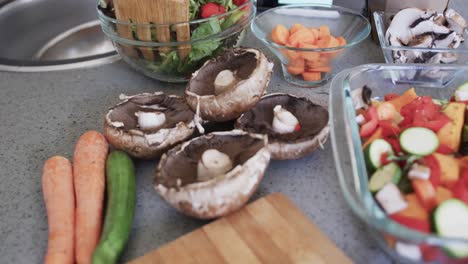 Close-up-of-vegetables,-baking-dish-and-salad-on-worktop-in-kitchen,-slow-motion