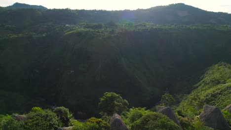 drone flying backwards revealing set of thatched roof cabin cottages hotel in tropical colombia