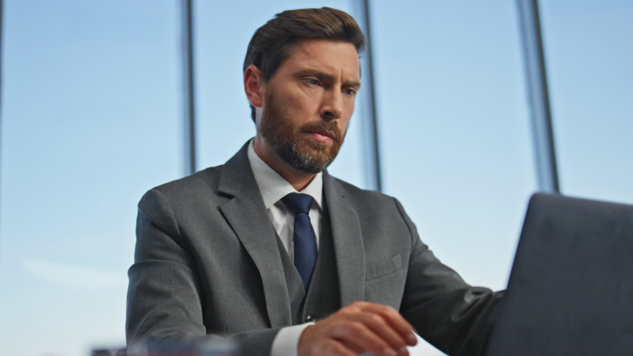 lavoratore serio che scrive e-mail che lavora sul computer in primo piano. uomo d'ufficio che chiude il portatile