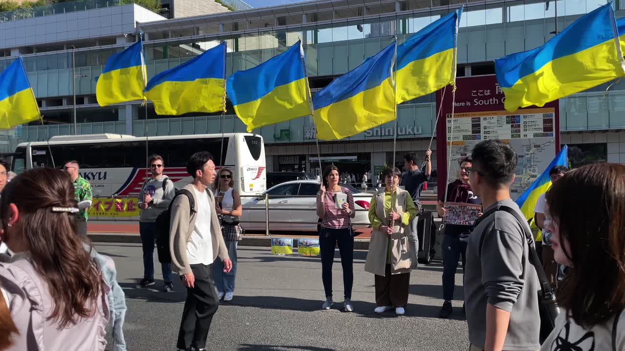 Tourists passing by a group of Ukraine-supporting protestors in front of Shinjuku Station in Tokyo Japan