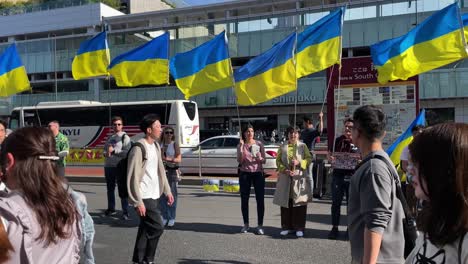 tourists passing by a group of ukraine-supporting protestors in front of shinjuku station in tokyo japan