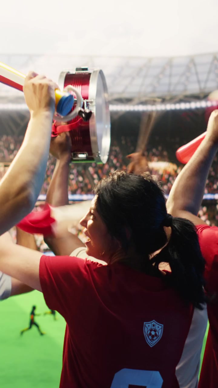 Video vertical: Primer plano de aficionados felices al fútbol cantando con vuvuzelas, caminando en el estadio