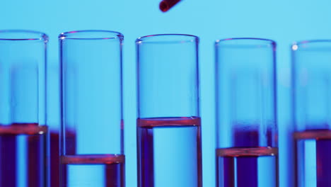 video of laboratory pipette and test tubes with copy space on blue background