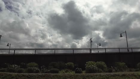 Rolling-view-of-the-11th-St-Bridge-in-the-Port-of-Tacoma,-Washington,-Partly-cloudy,-green-grass,-Concrete-colmns