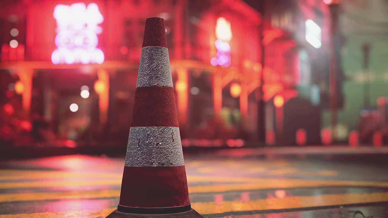 cono de tráfico en una calle de la ciudad por la noche