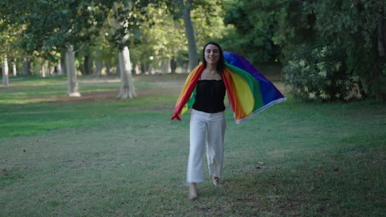 Woman Walking in a Park with a Pride Flag