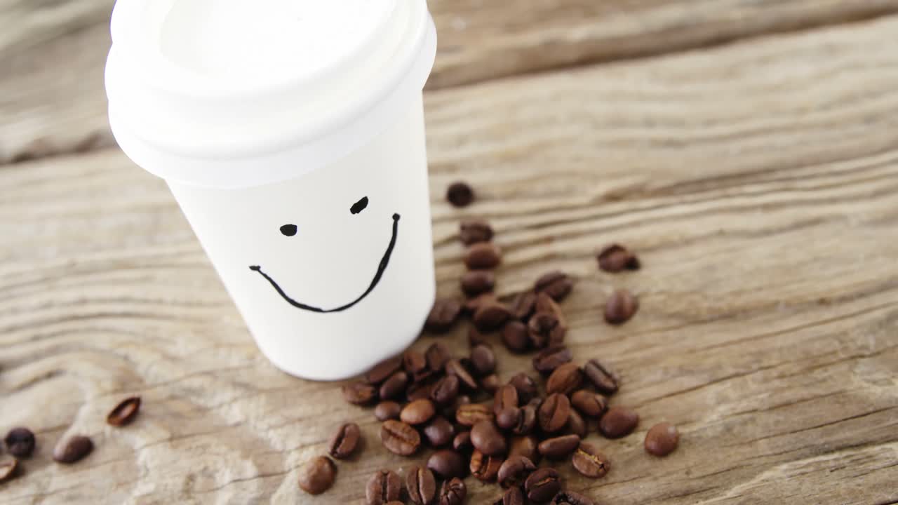 카페에 커피 콩을 넣은 일회용 컵에 미소 짓는 얼굴
