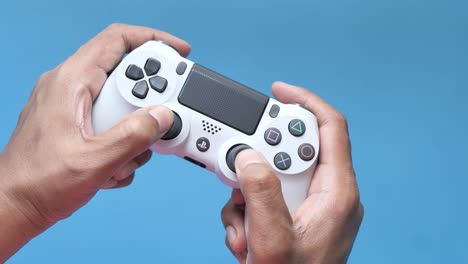 manos sosteniendo un controlador de playstation blanco