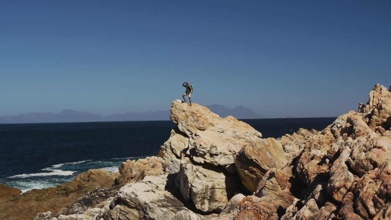 아프리카계 미국인 남자가 야외에서 운동하고 해안가의 시골에서 하이킹하고 있습니다.