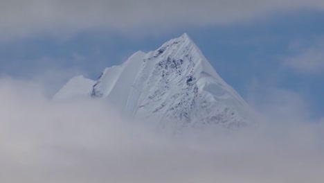 Snow-capped-peak-of-the-mountain,-between-clouds