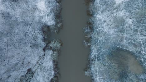 Vista-Aérea-De-Pájaro-Del-Valle-Del-Río-Abava-En-Un-Día-Nublado-De-Invierno,-Campos-Cubiertos-De-Nieve,-Río-Abava-Lleno-De-Agua-Oscura-De-Inundación,-Amplio-Disparo-De-Drones-Avanzando