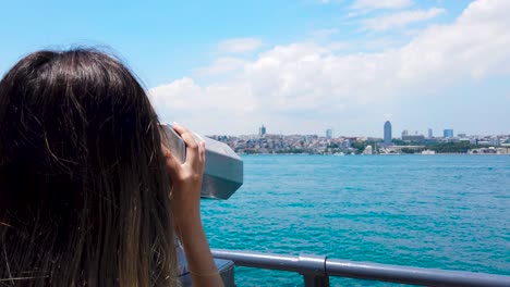 Beautiful-girl-looks-through-sightseeing-binoculars-on-Bosphorus,a-popular-destination-in-Uskudar,Istanbul,Turkey