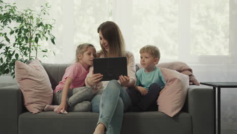 preschooler and toddler watch mother playing video game