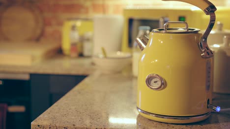 Fancy-yellow-kettle-boiling-water-for-coffee-and-tea-time-in-a-beautiful-kitchen