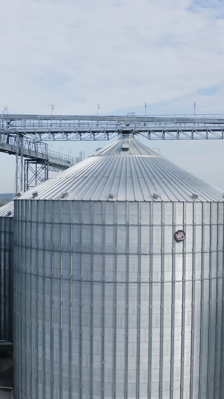 Big industrial steel elevator containers. Farming grain agricultural tanks. Vertical video
