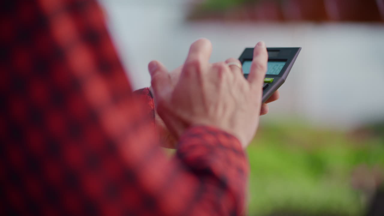 Gardener Using Calculator for Business Expenses