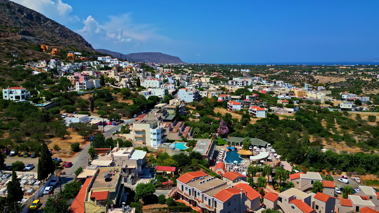 Traditional hillside houses, lush greenery, and distant sea. Piskopiano, Greece