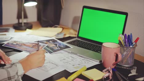 woman architect working on house plans at desk