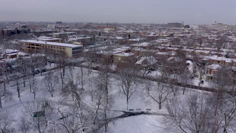 drone flying backward over a public parc in winter