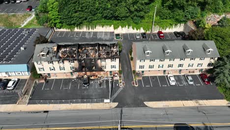 un complejo de apartamentos con una unidad quemada y colapsada después de un incendio