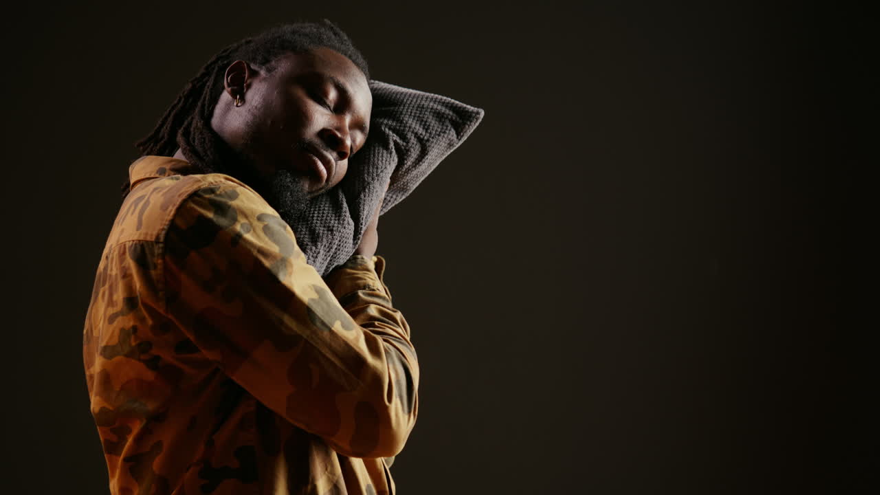 сонный человек дремлет с подушкой, пока он стоит