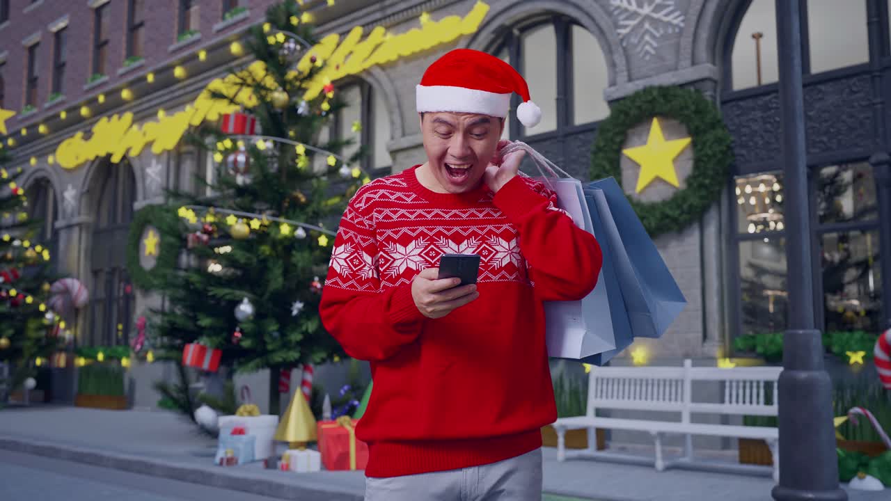 hombre asiático en traje de papá noel con las bolsas de compras diciendo wow y sonriendo mientras usa el teléfono inteligente en la noche de navidad