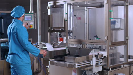 pharmaceutical worker operate industrial equipment at pharmaceutical plant