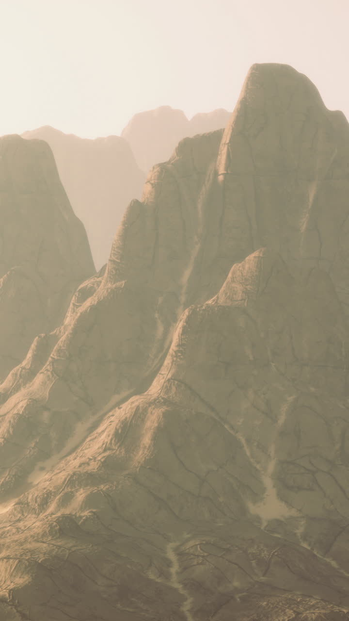 Vast desert landscape featuring majestic mountains under soft sunrise light