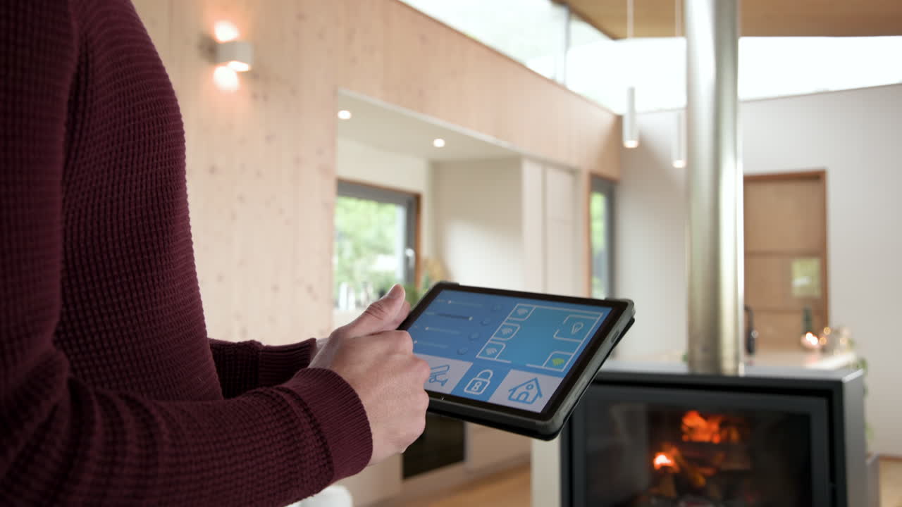 Person using tablet to control smart home features by cozy fireplace