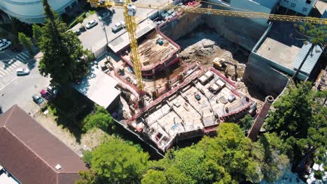 Aerial-timelapse-of-a-building-construction-site-with-bricklayers,-a-bulldozer-and-a-crane